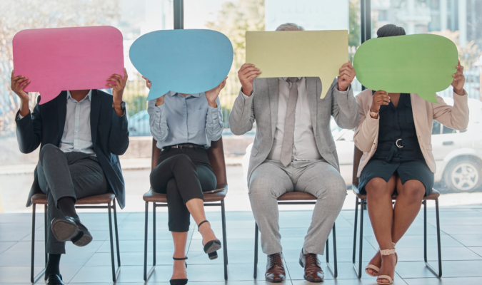 Photo of four people holding a comic book dialogue bubble card