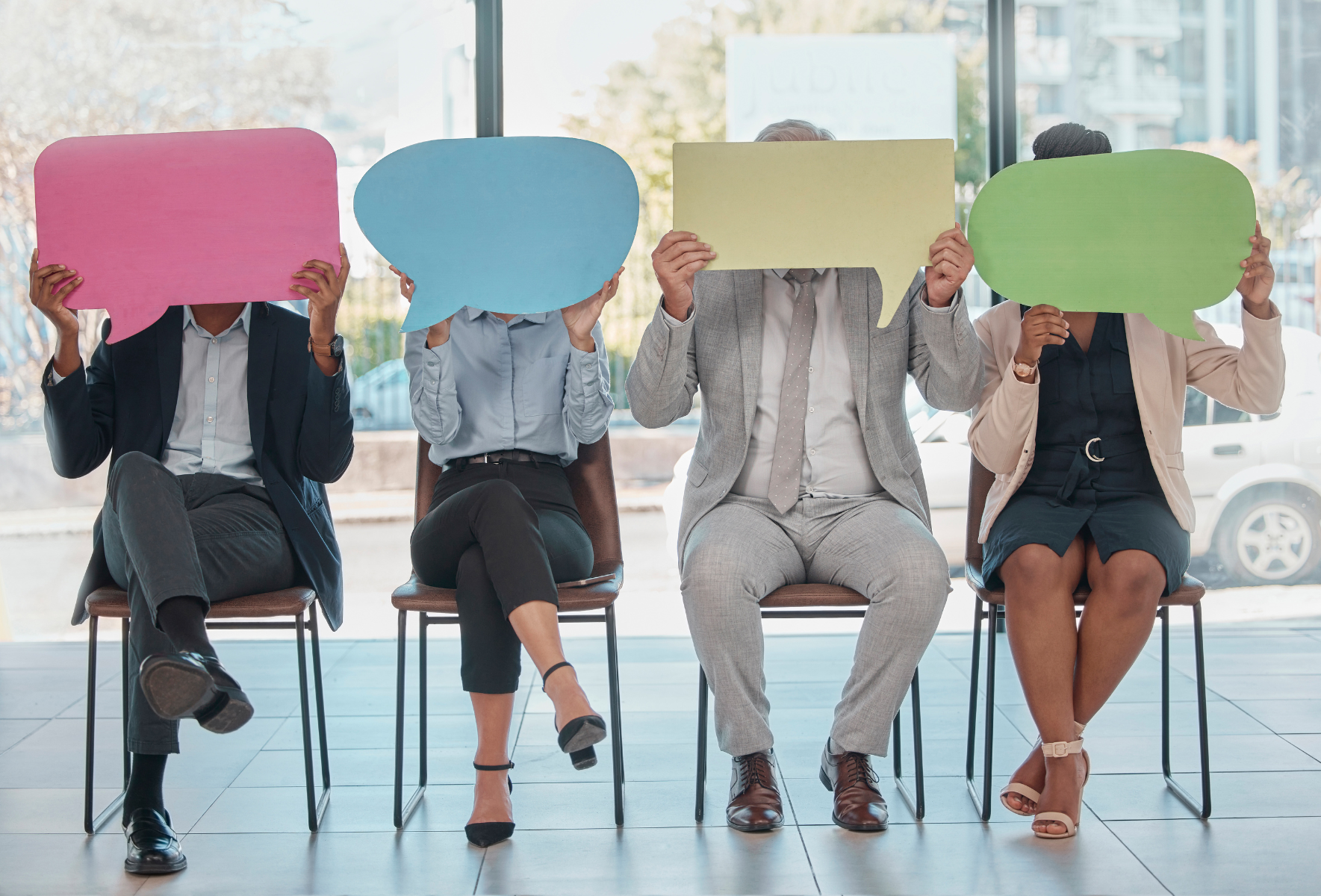 Photo of four people holding a comic book dialogue bubble card